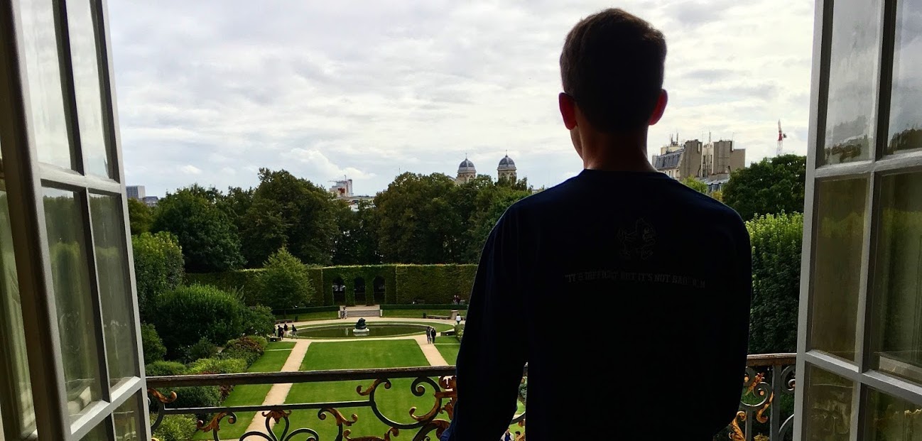 Student on a balcony overlooking a view of a park during Paris, France, study abroad program