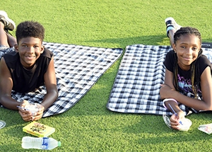 kids on a picnic blanket on green grass