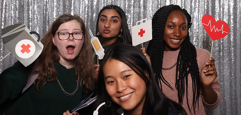 A group of young women posing for a photo with medicine props in their hands