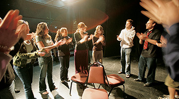 students on stage applauding