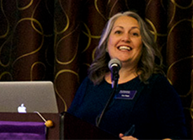 Kim Rapp speaking at the podium at an One World One Northwestern event