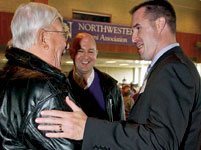 Norman Kragseth (SESP53), left, and son David Kragseth (C81, GC86) greet Wildcat football coach Pat Fitzgerald (SESP97) at the NAA